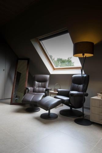 two chairs and a lamp in a room with a window at B&B Welcome Home in Laakdal