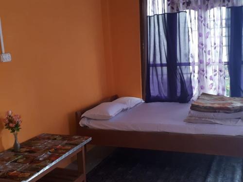 a small room with two beds and a window at Vamoose Arjastik Homestay in Pedong