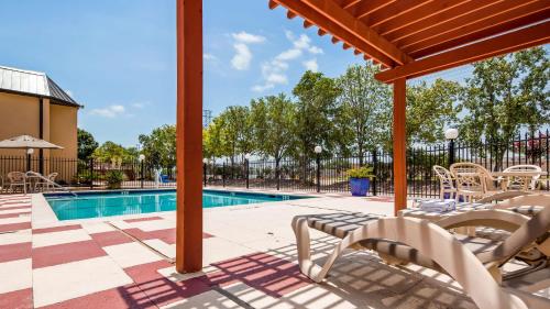 a patio with chairs and a swimming pool at Best Western Webster/NASA in Webster