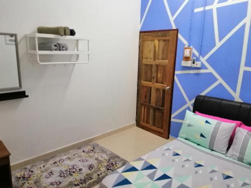 a room with a bed and a wooden door at Homestay Barakah Cenang Langkawi in Pantai Cenang