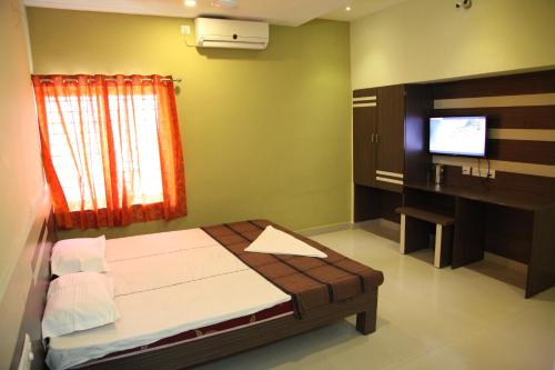 a bedroom with a bed and a television in it at Hotel Everest in Hyderabad