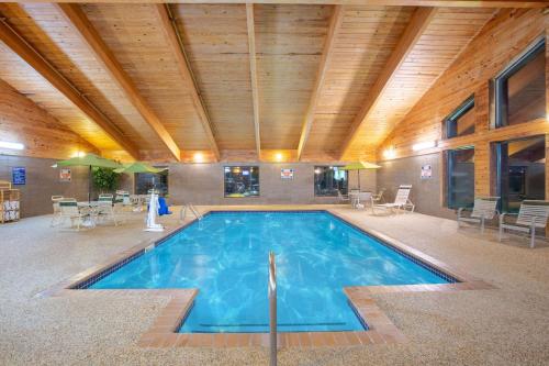 a large swimming pool in a building with a wooden ceiling at AmericInn by Wyndham Clear Lake in Clear Lake