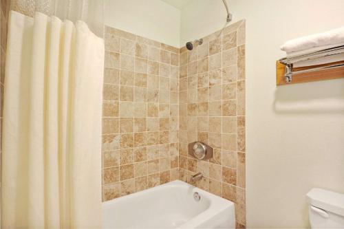 a bathroom with a tub and a shower curtain at Travelodge by Wyndham Seattle North of Downtown in Seattle