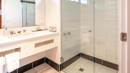 
a bathroom with a sink, mirror, and bathtub at Hideaway on George in Launceston
