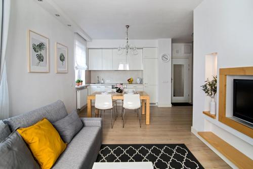 ein Wohnzimmer und eine Küche mit einem Sofa und einem Tisch in der Unterkunft Nadwiślańska Apartment in Warschau