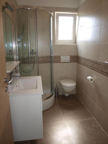 a bathroom with a shower sink and a toilet at Apartments Fran in Baška