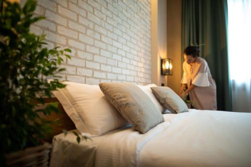 a woman standing next to a bed in a room at Hotel Locanda Al Piave ***S in San Donà di Piave