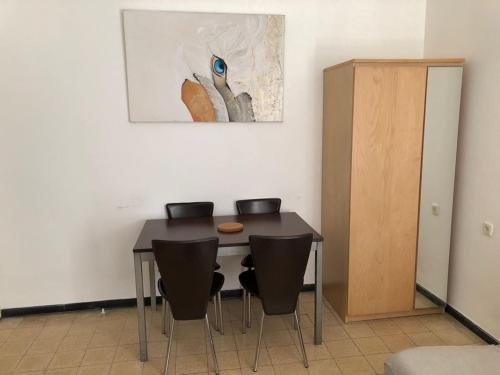 a dining room table with chairs and a painting on the wall at Home Tel Aviv by sourasky medical center ichilov in Tel Aviv