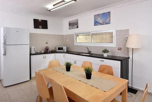 a kitchen with a dining table and a refrigerator at אחוזת חוף כנרת kinneret village in Tiberias
