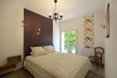 カヴァイヨンにあるGîte Rural "Chez Paulette" - Provence - Luberonのベッドルーム1室(ベッド1台、シャンデリア付)