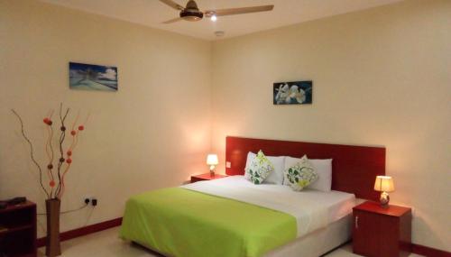 
a bedroom with a bed and a lamp on the wall at Precious Residence C in Grand'Anse
