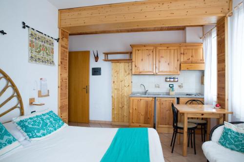 een slaapkamer met een bed en een tafel en een keuken bij Domus De Janas Sul Mare in Bari Sardo