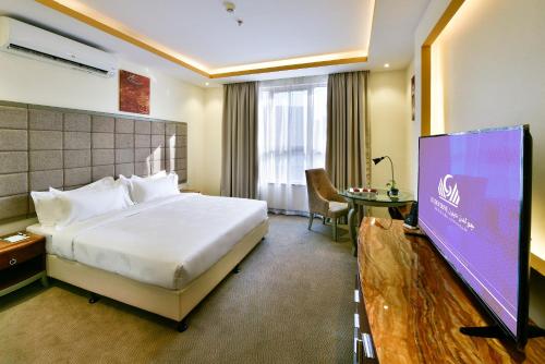 a hotel room with a bed and a projection screen at Golden dune Hotel Services-Turaif in Ţurayf