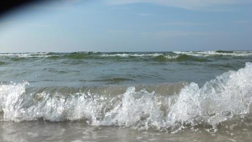 a wave in the ocean on a beach at Ferienwohnung "Schonzeit" in Graal-Müritz