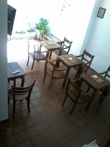 a group of wooden tables and chairs in a room at Secret Palace Guest house in Galle