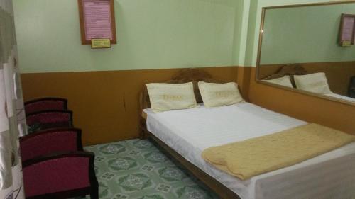 a bedroom with a bed and a mirror and chairs at Nhà nghỉ Hòa Yến 1 in Yên Bái