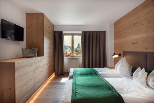a hotel room with a bed and a television at ride & relax Aparthotel Schwarz in Eben im Pongau