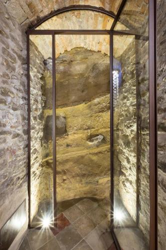a glass door in a stone wall with lights at Palazzo d'Assi - Guest house in Monforte dʼAlba