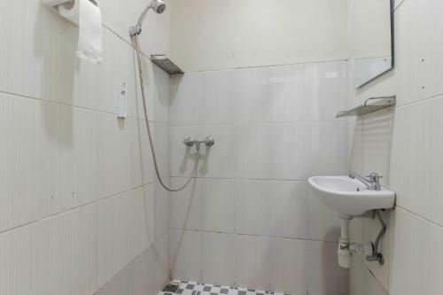 a white bathroom with a sink and a mirror at RedDoorz Plus near Lippo Cikarang Mall in Bekasi