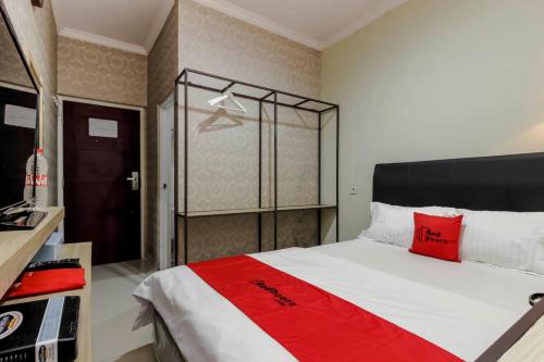 a bedroom with a large bed with red pillows at RedDoorz Plus near Lippo Cikarang Mall in Bekasi