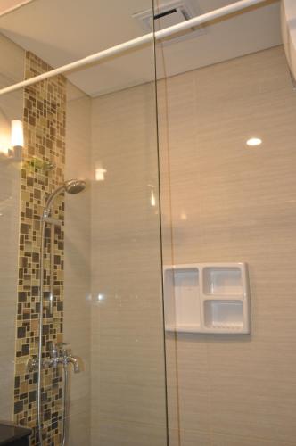 eine Dusche mit Glastür im Bad in der Unterkunft Apartment Greko Bandung in Bandung