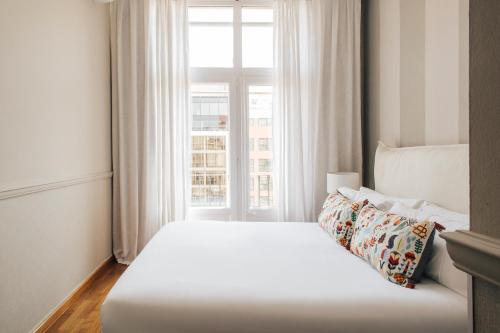 a white bed in a room with a window at Barcelona Apartment Val in Barcelona