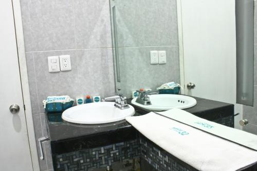 a bathroom with two sinks and a mirror at Aparthotel Siete 32 in Mérida