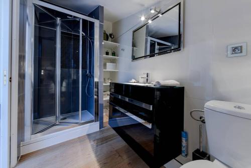 ein Bad mit einem Waschbecken und einer Glasdusche in der Unterkunft Elegante appartmento nel quadrato d'oro a St Tropez in Saint-Tropez