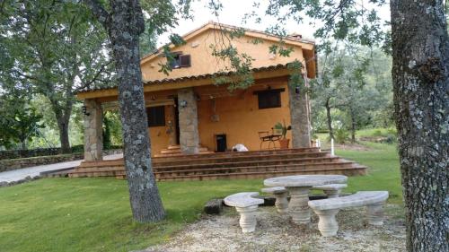 a house with a picnic table in front of it at LOS TASAJILLOS, Vivienda de uso Turístico in Candeleda