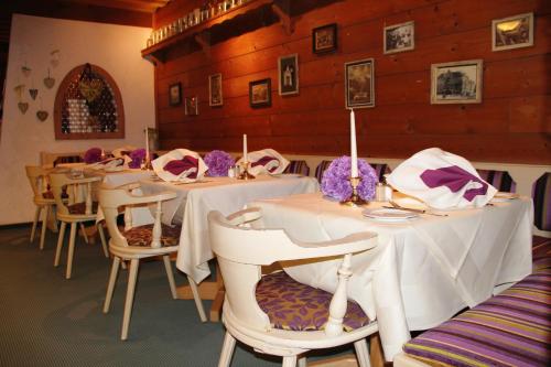 a group of tables with white table cloths on them at Hotel Bannwaldsee in Halblech
