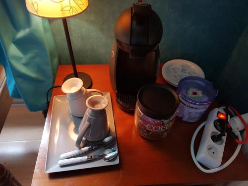 a table with a coffee maker and utensils on it at Château Lambert Moulinsart Hotel, shuttle airport, long term parking, snooker, large terrasse, dinner, breakfast in Charleroi