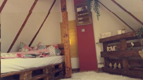 1 dormitorio con cama y escalera de madera en uebernachtung unna en Unna