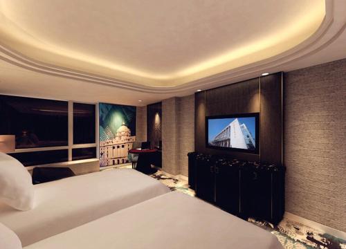 a bedroom with two beds and a flat screen tv at Oriental Riverside Bund View Hotel (Shanghai International Convention Center) in Shanghai