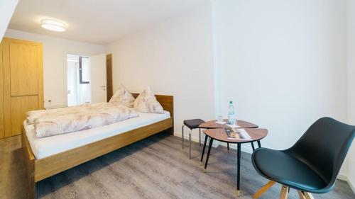 Schlafzimmer mit einem Bett, einem Tisch und Stühlen in der Unterkunft Hotel Seeadler in Friedrichshafen