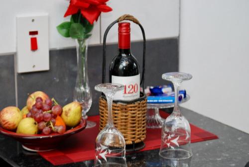 a bottle of wine and two glasses and a basket of fruit at Tranquility in Longford