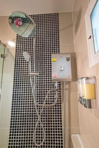 a shower in a bathroom with a tiled wall at Aonang Sweet Blue Sea in Ao Nang Beach