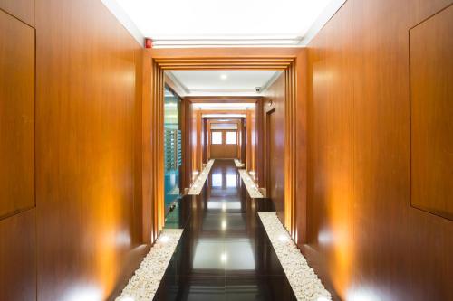 a corridor of a building with wooden walls and a long hallway at Romantic Khon Kaen Hotel in Khon Kaen