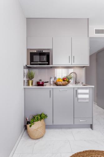 a kitchen with white cabinets and a bowl of fruit at Skyreach BizzStay - Wohnen am Main in Frankfurt/Main