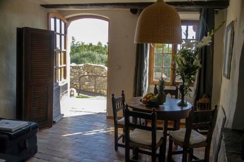 une salle à manger avec une table, des chaises et une porte ouverte dans l'établissement la maison aux bonsais, à Saint-Paul-de-Vence