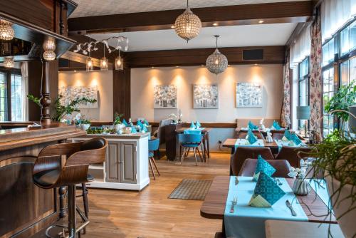 ein Restaurant mit blauen Tischen und Stühlen und eine Bar in der Unterkunft Restaurant Landgasthof Zum Wiesengrund in Newel
