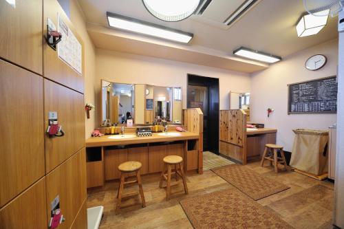 a bathroom with a sink and a counter with two stools at Dormy Inn Matsumoto in Matsumoto