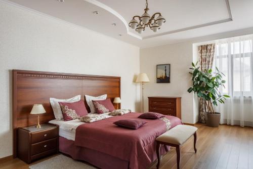 a bedroom with a large bed with a red blanket at Hotel Yuzhnaya Bashnya in Krasnodar