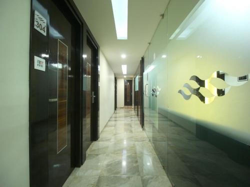 a hallway of an office building with a hallway at Hotel Furaat Inn in Ahmedabad
