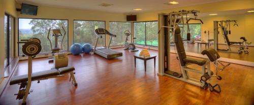 a gym with several treadmills and machines in a room at The Aberdare Country Club in Mweiga