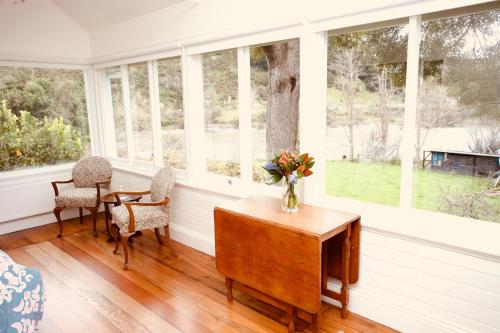 a room with a table and chairs and windows at The Signal Box in Whanganui