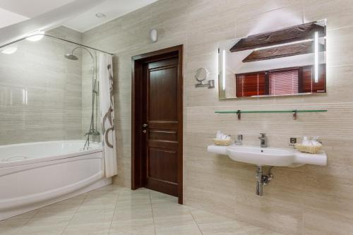 a bathroom with a sink and a bath tub at Hotel Yuzhnaya Bashnya in Krasnodar