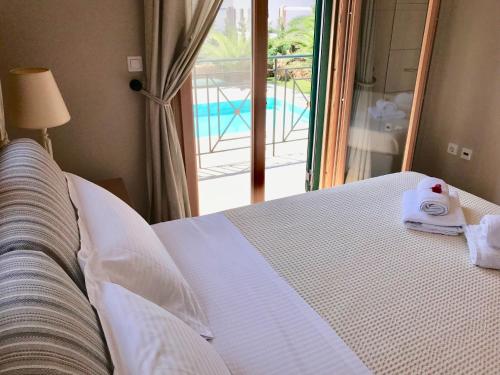 a bedroom with a bed with towels on it at Dolce Vita East in Svoronata