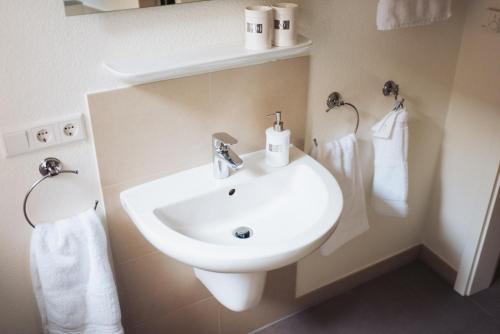 a bathroom with a white sink and towels at Anker Mal in Husum