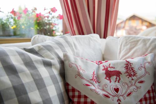 a couch with two pillows on it with a window at Hotel Alphorn in Gstaad
