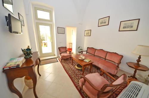 a living room with a couch and chairs and a tv at Casa Branca in Castrignano del Capo